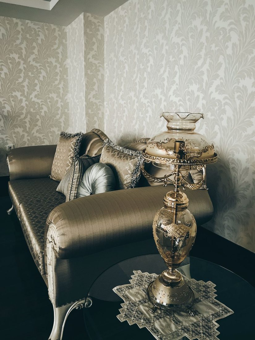 Glass table lamp beside a sofa