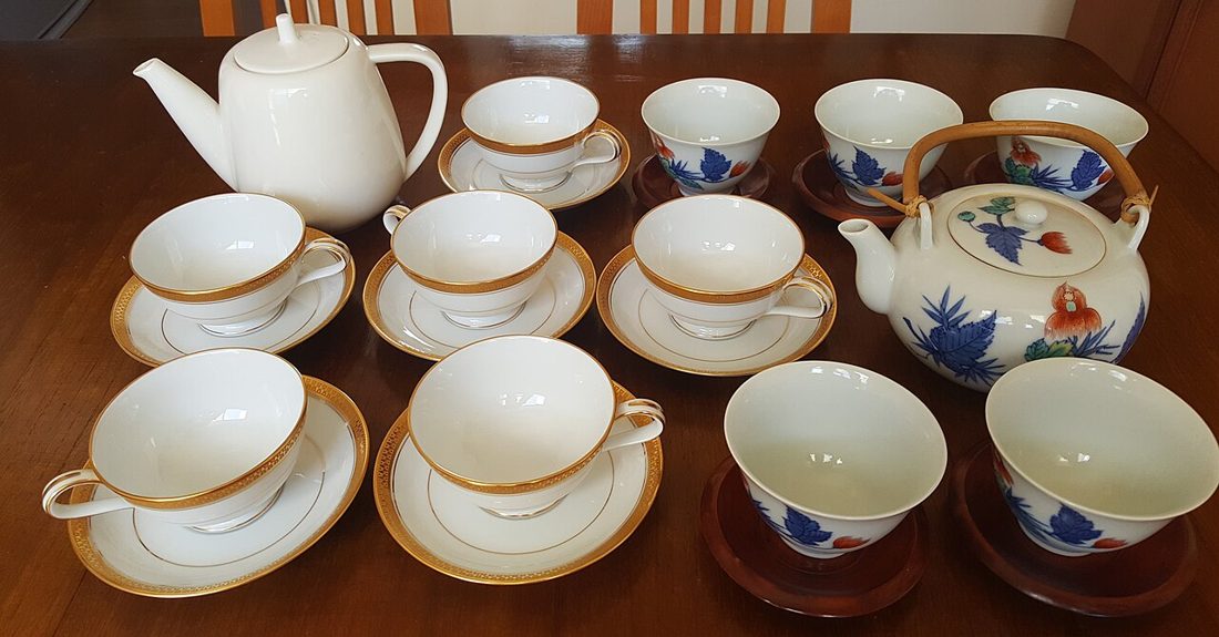 Porcelain tea and coffee sets laid out on a table